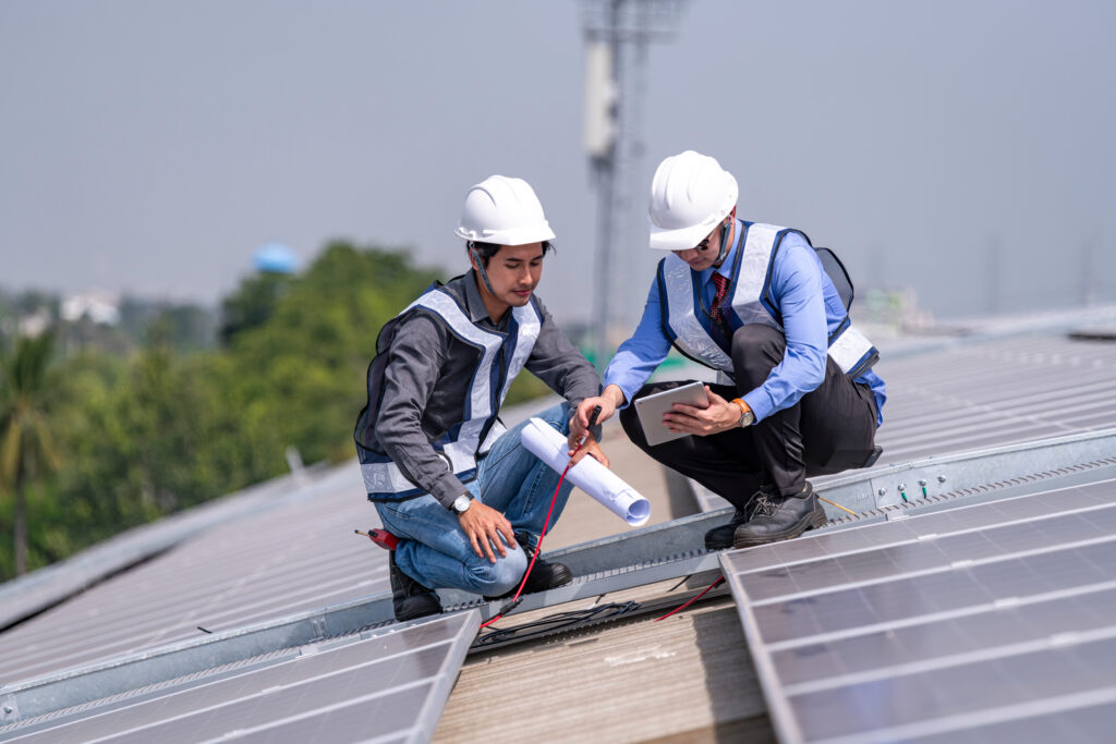 現場で太陽光発電設備について打ち合わせをする作業員と担当者